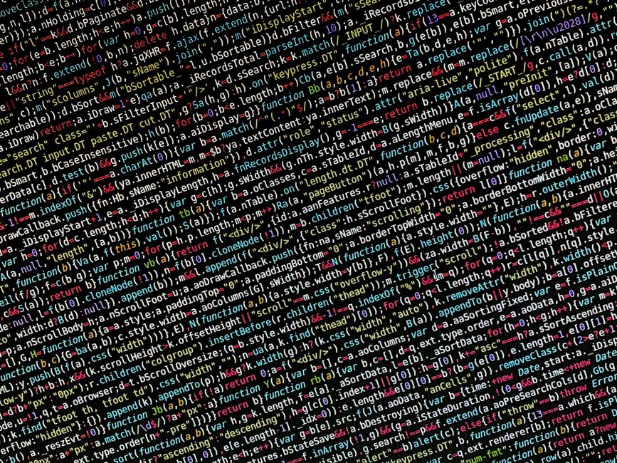 A close-up photograph of a computer screen displaying lines of colorful programming code. The code includes various syntax elements such as functions, variables, and conditional statements, rendered i